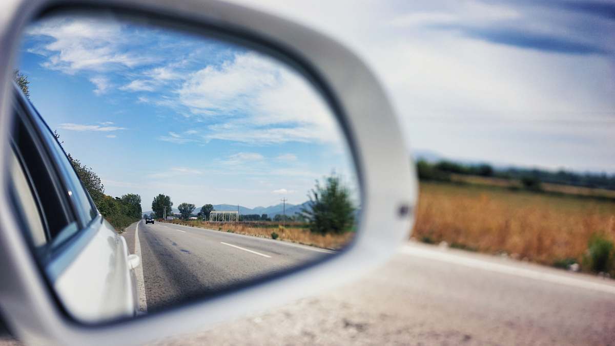 car mirror vehicle side mirror viewing car on the road during day asphalt